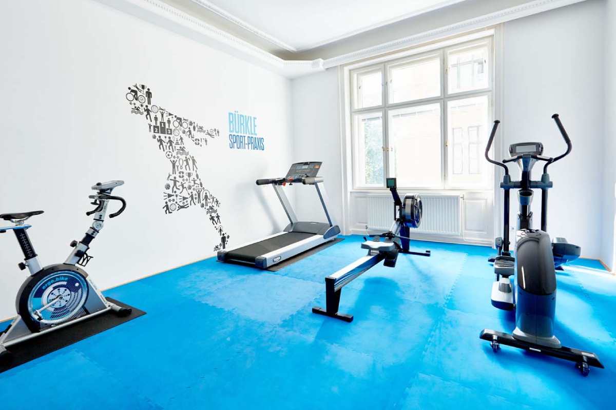 ein Praxisraum in blau und weiß mit Fitnessgeräten
